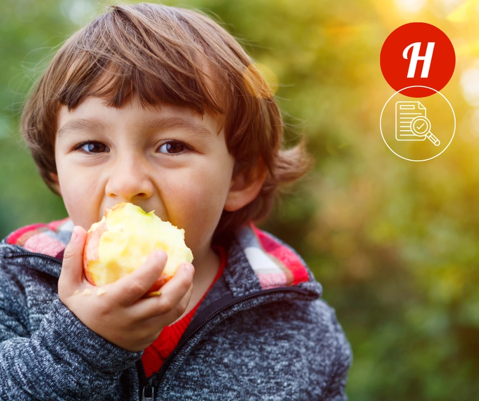 Young boy eating an apple considering fruit traceability