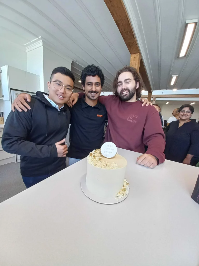 Three guys enjoy cake to celebrate becoming full-time employees.